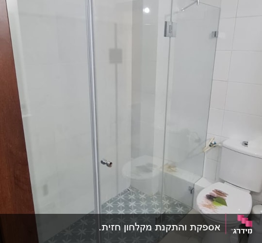 מקלחת עם דלת זכוכית וראש מקלחת עגול